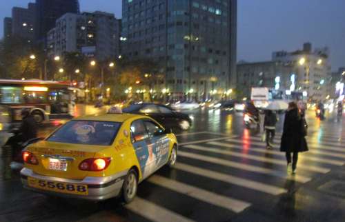 A Taipei taxi driving down the pedestrian crossing while trying to merge into traffic.